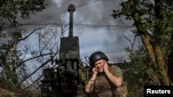 Ukrainian servicemen fire a self-propelled howitzer toward Russian positions on a frontline in the Zaporizhzhya region