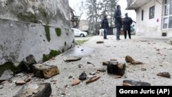 Helybeliek szemlélik a földrengés okozta károkat a horvátországi Sisakban, 2020. december 28-án