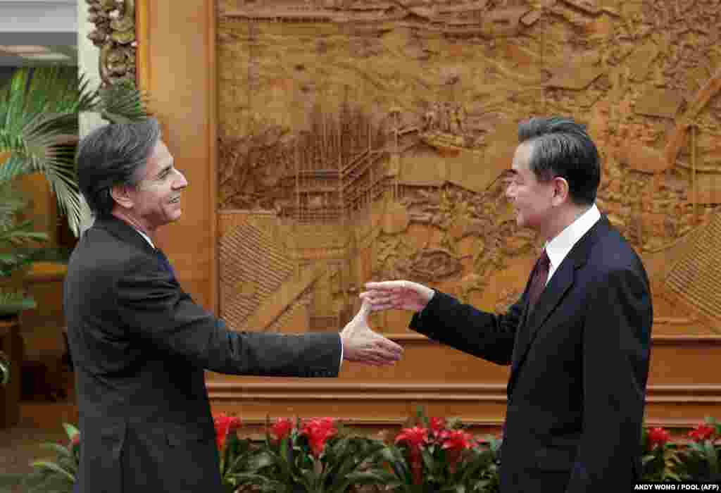 Antony Blinken és Wang Yi kínai külügyminiszter kezet fognak egy 2015-ös találkozón Beijingben.
