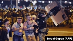 Riot police detain a group of demonstrators during a protest after polls closed in Belarus's presidential election in Minsk on August 9, 2020. 