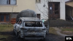 Запаленият автомобил в двора на къщата на кмета на Бистрица Самуил Попов. Палежът е засегнал и входната врата на имота. 16 февруари 2026 г.