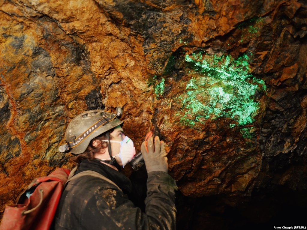 Радиоактивни отунитови кристали светят под UV фенерче в изоставена уранова мина в Южна Бохемия.