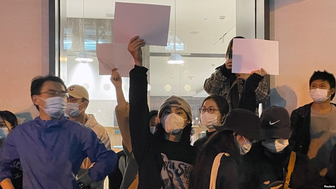 Protestatari chinezi țin foi albe de hârtie în mână, în timpul unei demonstrații împotriva restricțiilor Covid, în Shanghai, China, 27 noiembrie 2022. „Hârtiile albe reprezintă tot ceea ce vrem să spunem, dar nu putem”, afirmă un manifestant.