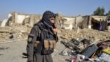 A Taliban security officer stands near a damaged house in Kandahar province on October 16.