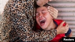 Palestinka tješi dječaka u bolnici u Deir al Balahu u kojoj su dovezeni ranjeni i ubijeni u novim izraelskim napadima, centralno područje Pojasa Gaze, 10. jula 2025.