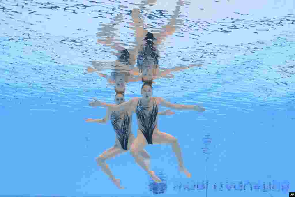Arina Pushkina and Yasmin Tuyakova of Kazakhstan compete in an artistic swimming competition at the World Aquatics Championships in Singapore.