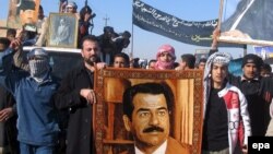 Iraqis in Tikrit protest carry portraits of Saddam Hussein at a demonstration in 2007, the year after his execution.