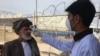 An Afghan health worker checks the temperature of people returning from Iran at the Islam Qalah border crossing on February 23.