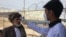 An Afghan health worker checks the temperature of people returning from Iran at the Islam Qalah border crossing on February 23.
