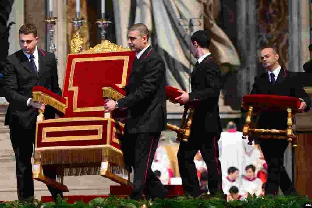 Assistants carry Pope Benedict XVI&#39;s armchair prior to a Mass on Ash Wednesday at St. Peter&#39;s basilica at the Vatican. (AFP/Gabriel Bouys)