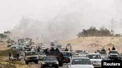 Rebel fighters flee from Ajdabiyah, on the road to Benghazi, on March 15.