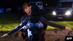 A policewoman frisks an Afghan refugee at the German-Austrian border near Piding in September.