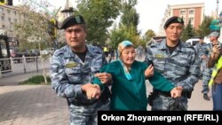 Казак полициясы митингге чыккан аялды кармап баратат. 21-сентябрь, 2019-жыл. 