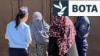 Zyrtaret policore duke biseduar me gratë në Osh lidhur me ndalesën e nikabit. 