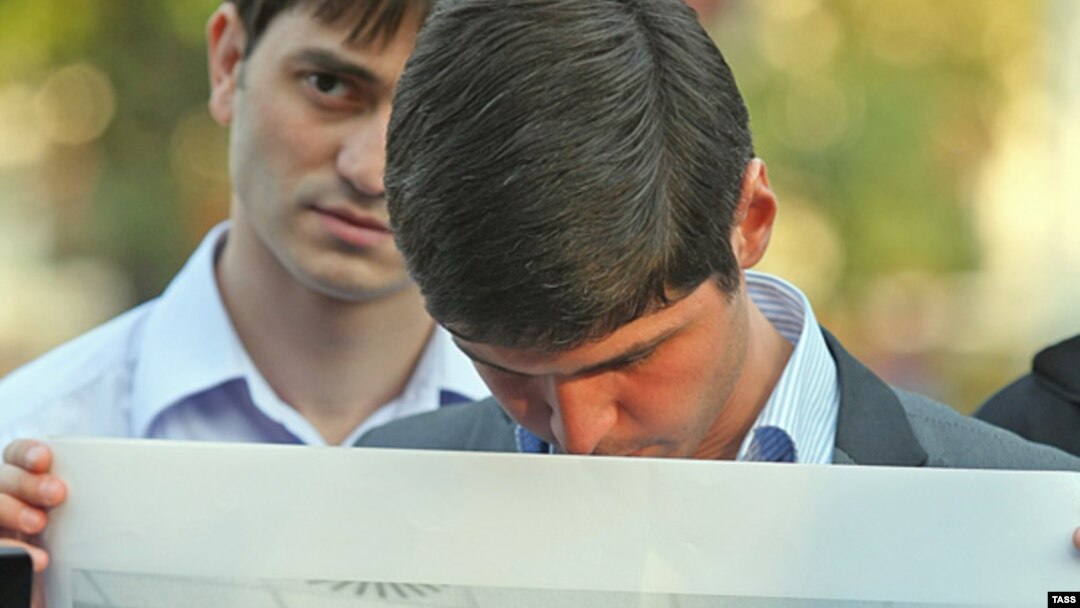 An opposition activist holds a portrait of Magomed Yevloyev during a protest in Moscow last year.