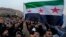 Syrian citizens wave the revolutionary flag and shout slogans as they celebrate in Damascus on December 9.