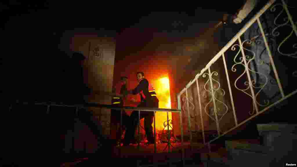 Palestine -- Firefighters try to extinguish a fire after an Israeli air strike, witnessed by a Reuters journalist, on a floor in a building that also houses international media offices in Gaza City, 19Nov2012