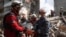Rescuers carry the body of a person recovered from the debris at the site of an apartment building hit during a Russian missile and drone strike.