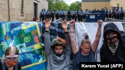 Протестующие в США подняли руки с требованием справедливости для погибшего Джорджа Флойда, в то время как полиция пустила слезоточивый газ. 27 мая 2020 года, Миннеаполис, США.