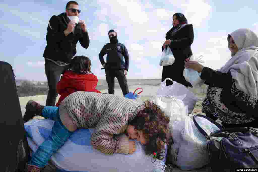 A child lies on a sack as migrants rest on their way to Greece near the Pazarakule border crossing near Edirne, Turkey.