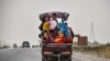 Afghan children travel on a three-wheel vehicle in Balkh Province.&nbsp;