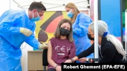 O tânără adolescentă din România este vaccinată cu prima doză de către Valeriu Gheorghiță, președintele CNCAV.
