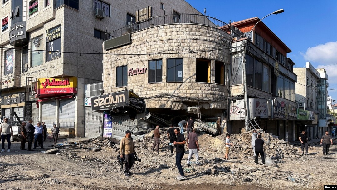 Palestinieni evaluează pagubele de pe stradă în urma unei operațiuni militare israeliene în Jenin, în Cisiordania ocupată de Israel. 6 septembrie 2024. 