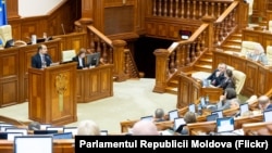 Secretarul general al Guvernului, Alexei Buzu (la tribună), prezintă deputaților proiectul de modificări la legea privind amalgamarea voluntară, 9 aprilie 2026.