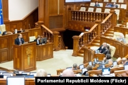 Secretarul general al Guvernului, Alexei Buzu (la tribună), prezintă deputaților proiectul de modificări la legea privind amalgamarea voluntară, 9 aprilie 2026.