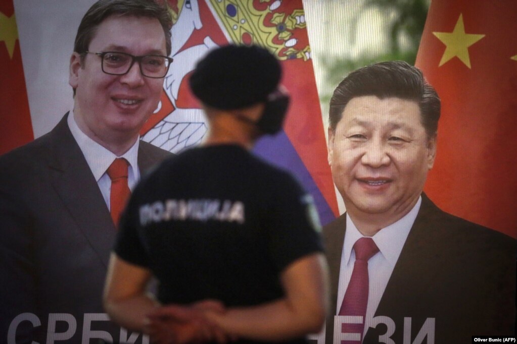 Një polic duke bërë rojë pranë një pankarte me fotografinë e presidentit serb, Aleksandar Vuçiq, dhe të udhëheqësit kinez, Xi Jinping, në Beograd, në vitin 2020.