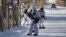 Сотрудники правоохранительных органов стоят на страже возле местной школы после того, как ученик с топором напал на школьников и учителя в городе Улан-Удэ. Россия, 19 января 2018 года