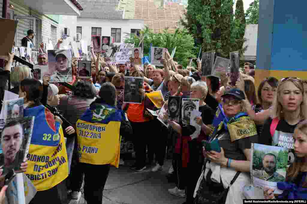 Ті, хто ще не дочекався рідних з полону, показують фотографії своїх близьких у полоні щойно звільненим – в надії, що ті їх впізнають і розкажуть якусь інформацію. Чернігівщина, травень 2025 року