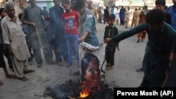 Pakistani protesters burn a poster image of Christian woman Asia Bibi in the southern city of Hyderabad on November 1.