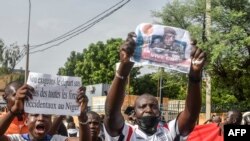 Un susținător ține o fotografie a generalului Abdourahamane Tiani, șeful puternicei gărzi prezidențiale care a preluat puterea în Niger.