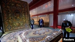 People look at the carpets displayed at the Iran section of the Baghdad International Fair, in Baghdad, Iraq November 10, 2018. Picture taken November 10, 2018. REUTERS/Thaier al-Sudani