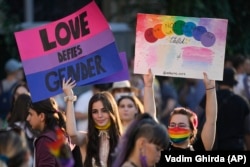 Participants hold banners during Bucharest Pride 2021.