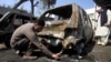 A Pakistani policeman looks for evidence after a deadly suicide attack in Shabqadar on March 7.