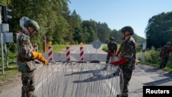 Члены Союза стрелков Литвы устанавливают колючую проволоку на переходе границы с Беларусью в Сумскасе. Литва, 18 августа 2023 года