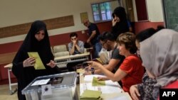 A woman votes in snap Turkish presidential and parliamentary elections in Istanbul on June 24,