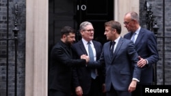Ukrainian President Volodymyr Zelenskyy (left) shakes hands with French President Emmanuel Macron in front of 10 Downing Street after a meeting in London that was also attended by UK Prime Minister Keir Starmer (second left) and German Chancellor Friedrich Merz (right) on December 8
