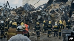 Emergency service personnel work at the site of a destroyed building in Odesa on July 20 after Russia pounded the Ukrainian port city with drones and missiles for a third consecutive night.