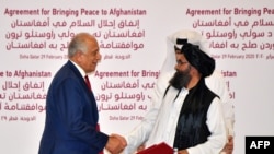 U.S. Special Representative for Afghanistan Reconciliation Zalmay Khalilzad and Taliban co-founder Mullah Abdul Ghani Baradar shake hands after signing a peace agreement during a ceremony in the Qatari capital Doha on February 29.