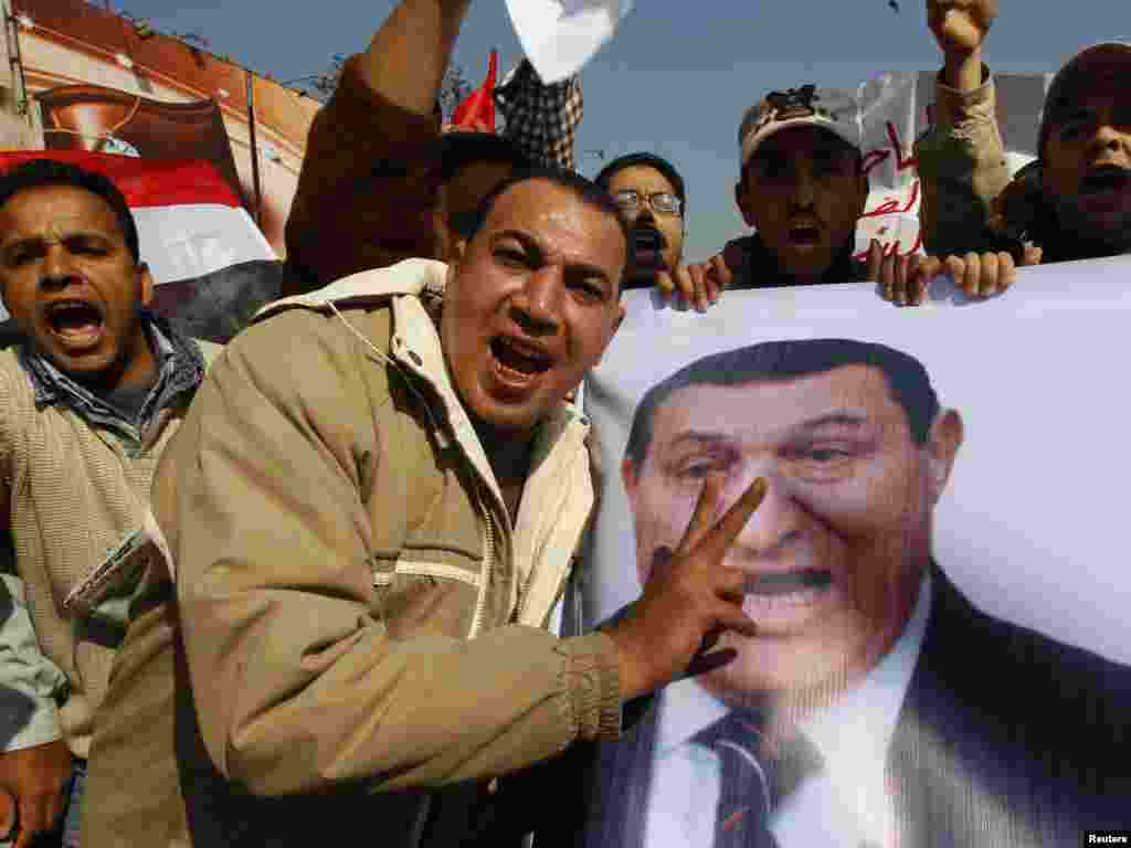 Mubarak supporters carry a banner of the president at a march near Tahrir Square.