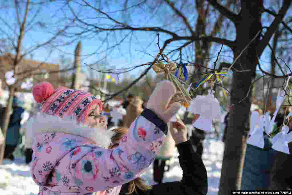 Діти й активісти на Алеї Героїв Небесної сотні розвісили на гілках дерев білих паперових янголів, щоб ушанувати пам'ять загиблих за Україну Героїв