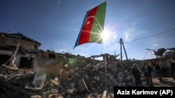 AZERBAIJAN -- Azerbaijani national flag flies over destroyed houses in a residential area that was hit by rocket fire overnight by Armenian forces, in Ganca, October 22, 2020