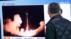 Un bărbat din Coreea de Sud se uită la un ecran TV care afișează o imagine de a lansării unei rachete de către Coreea de Nord. Fotografie generică.