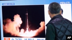 Un bărbat din Coreea de Sud se uită la un ecran TV care afișează o imagine de a lansării unei rachete de către Coreea de Nord. Fotografie generică.