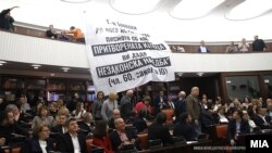 Пратеници од ВМРО-ДПМНЕ на денешната јавна расправа за предлог законот за јавно обвинителство во Собранието, истакнаа транспарент на галеријата на кој пишува „Господине Јовески до кога ќе го криете писмото со кое притворената Катица ви даде незаконска наредба (чл.60, законот за Ј