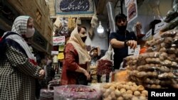 FILE PHOTO: Women wearing protective face masks shop at a bazaar following the outbreak of the coronavirus disease (COVID-19), in Tehran, Iran, July 8, 2020. 