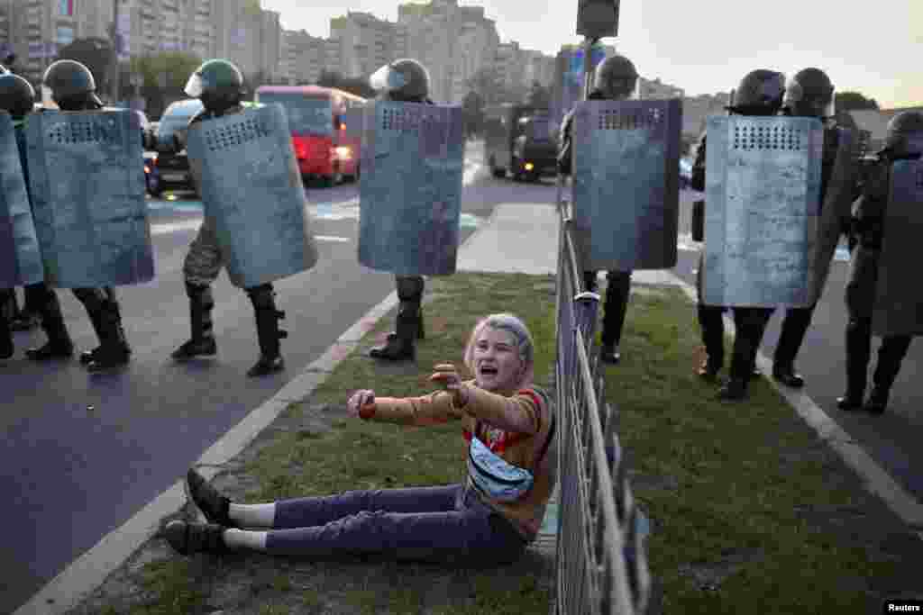 A woman reacts near Belarusian law enforcement officers, who brutally dispersed crowds during protests against the inauguration of Alyaksandr Lukashenka in Minsk on September 23. (Tut.by via Reuters)